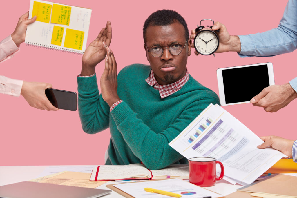 african american man sitting desk surrounded with gadgets papers 1